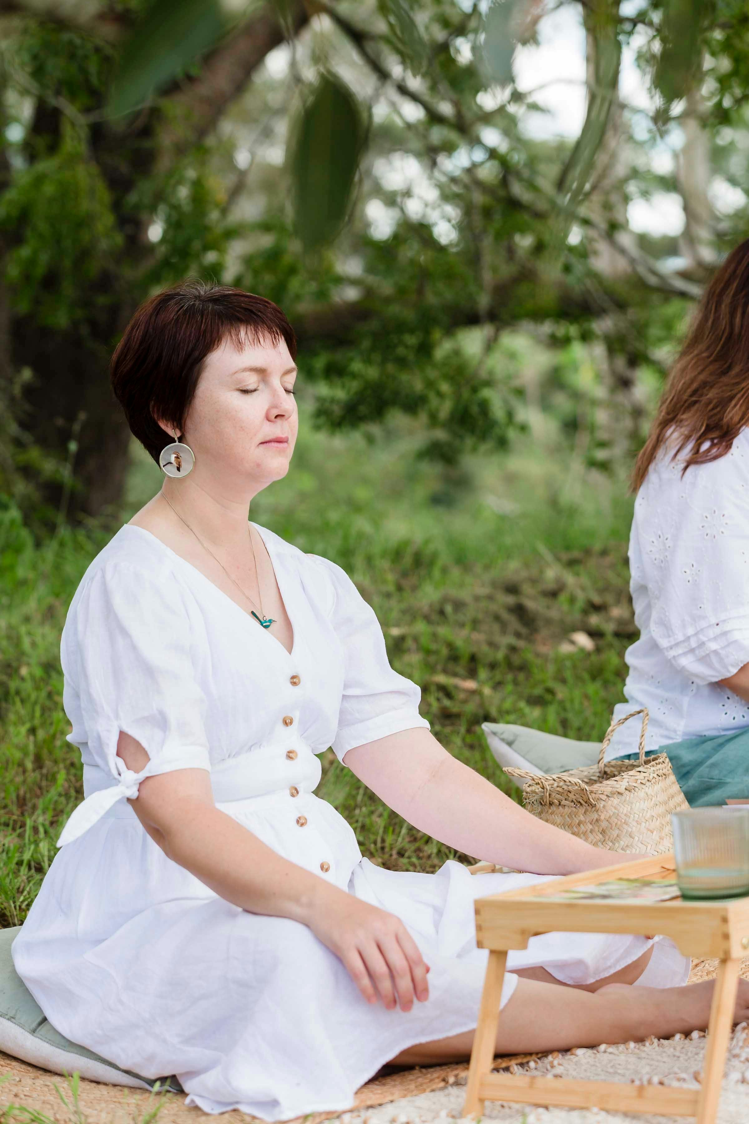 Woman meditating in a white dress