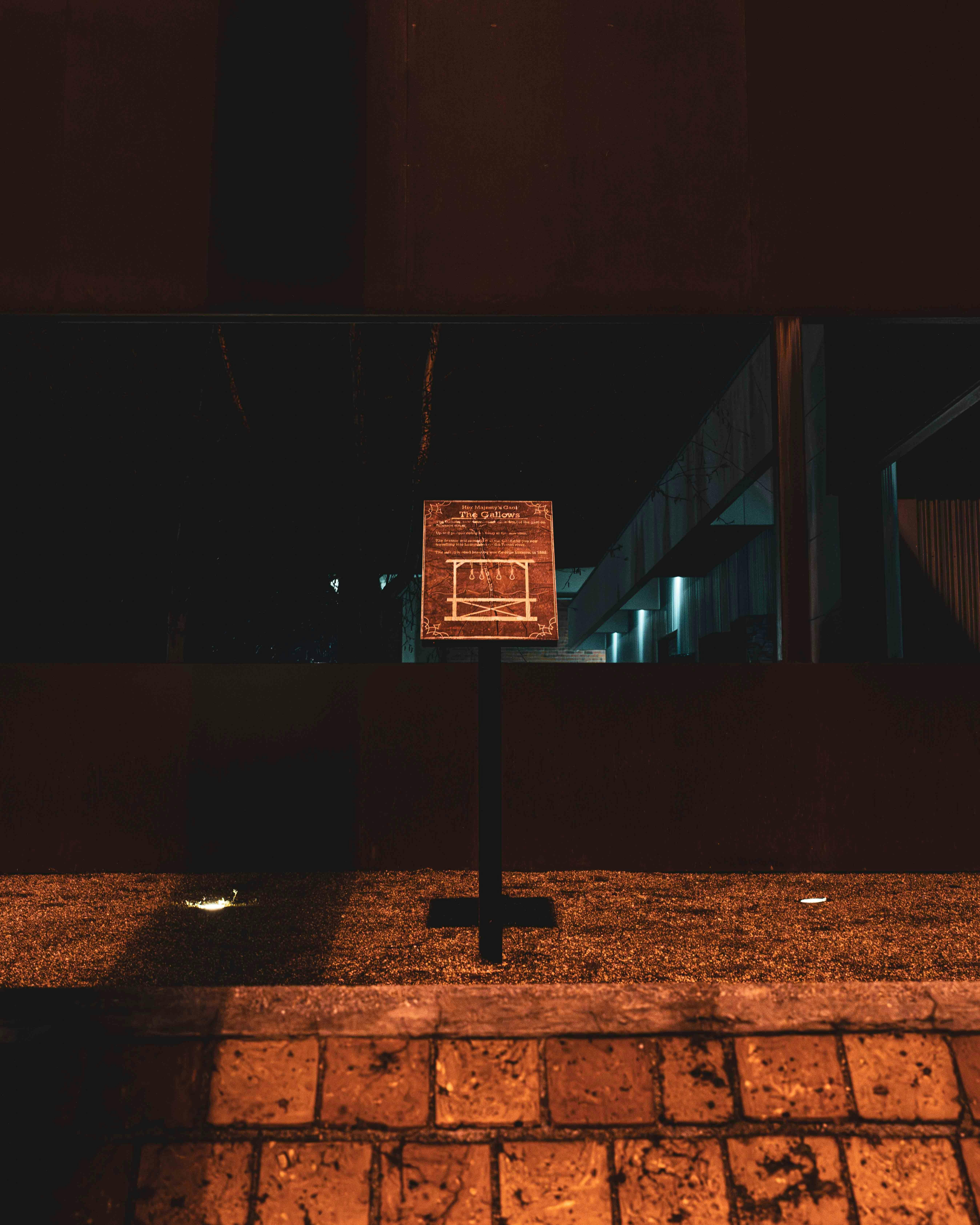 The Gallows historical interpretation sign illuminated at night in central Launceston.