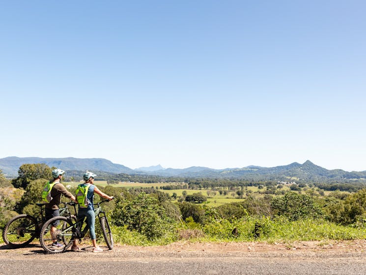 Two riders admiring the view to Mount Warning over the Byron Bay hinterland