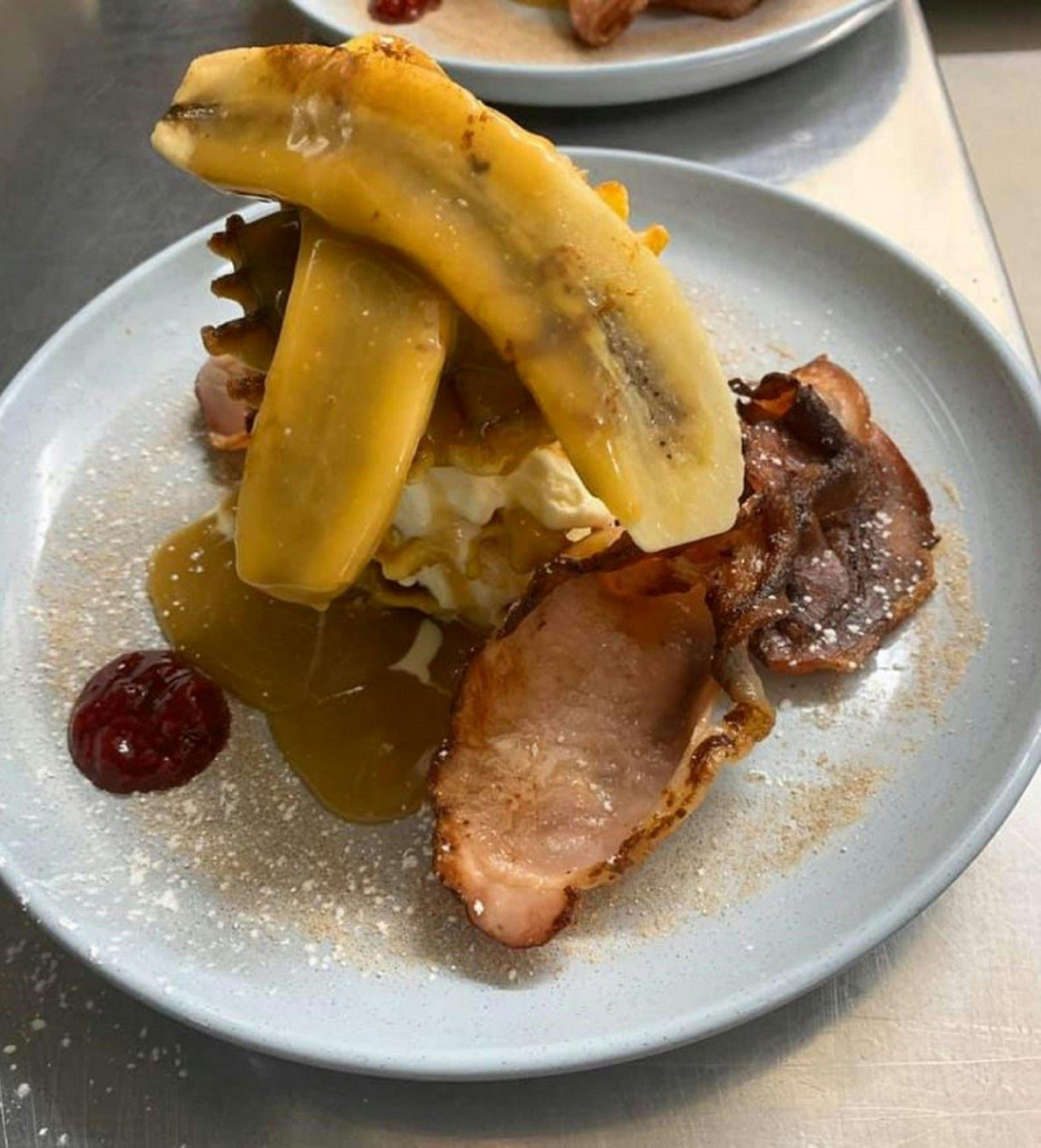 Breakfast waffle with banana, bacon and maple syrup