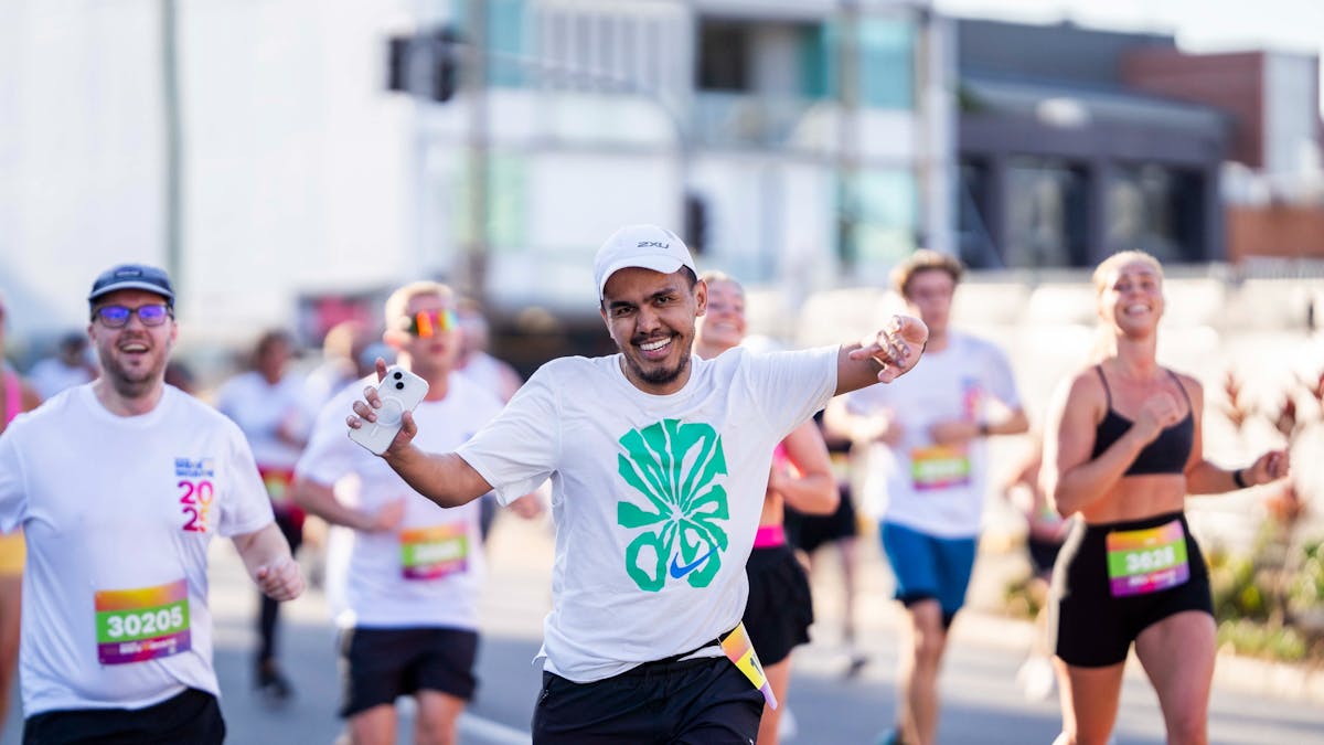 Man running the 5km race, his arms are up in the air.