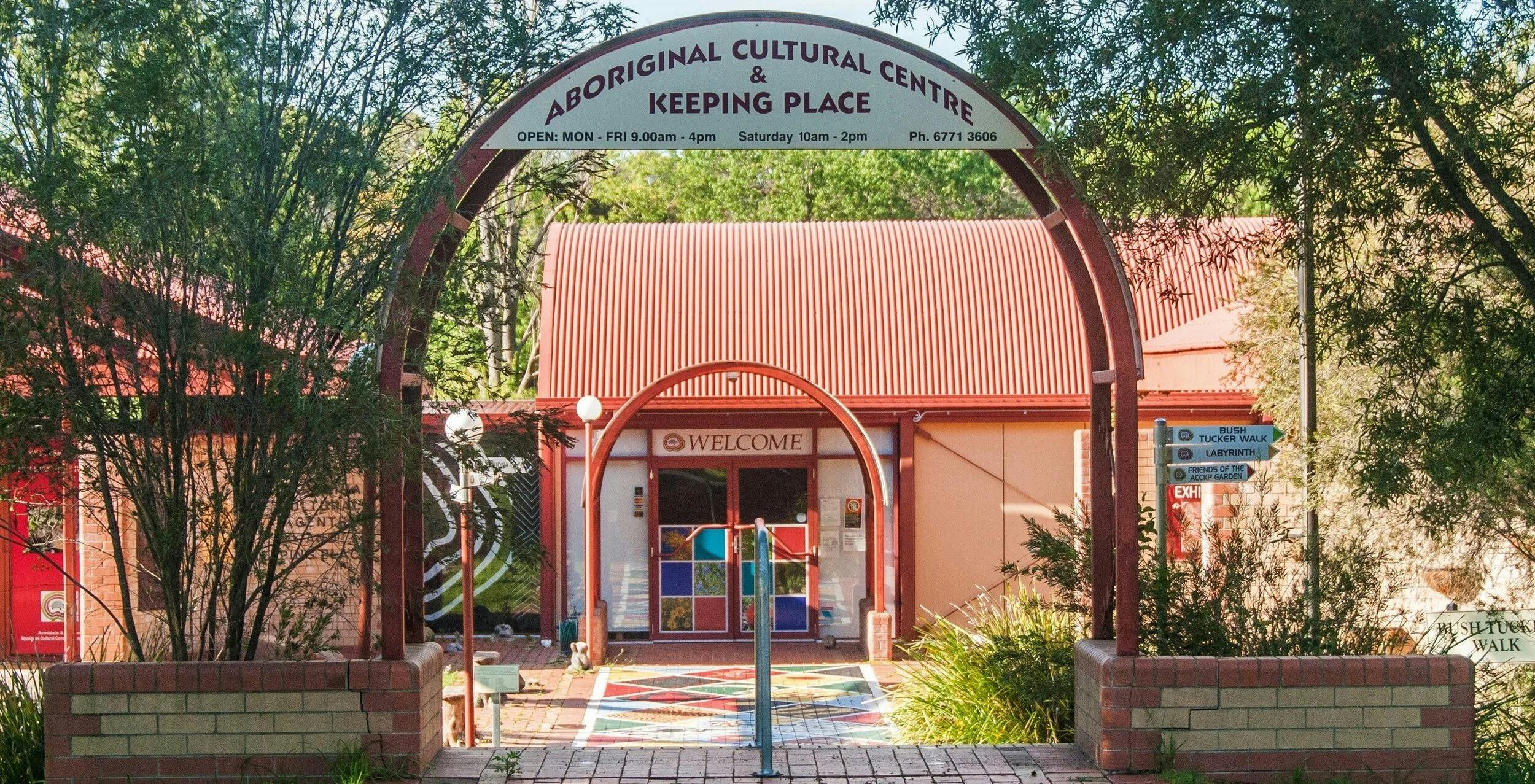 Main entry walkway to ACCKP, sign above the entry steps includes opening hours.