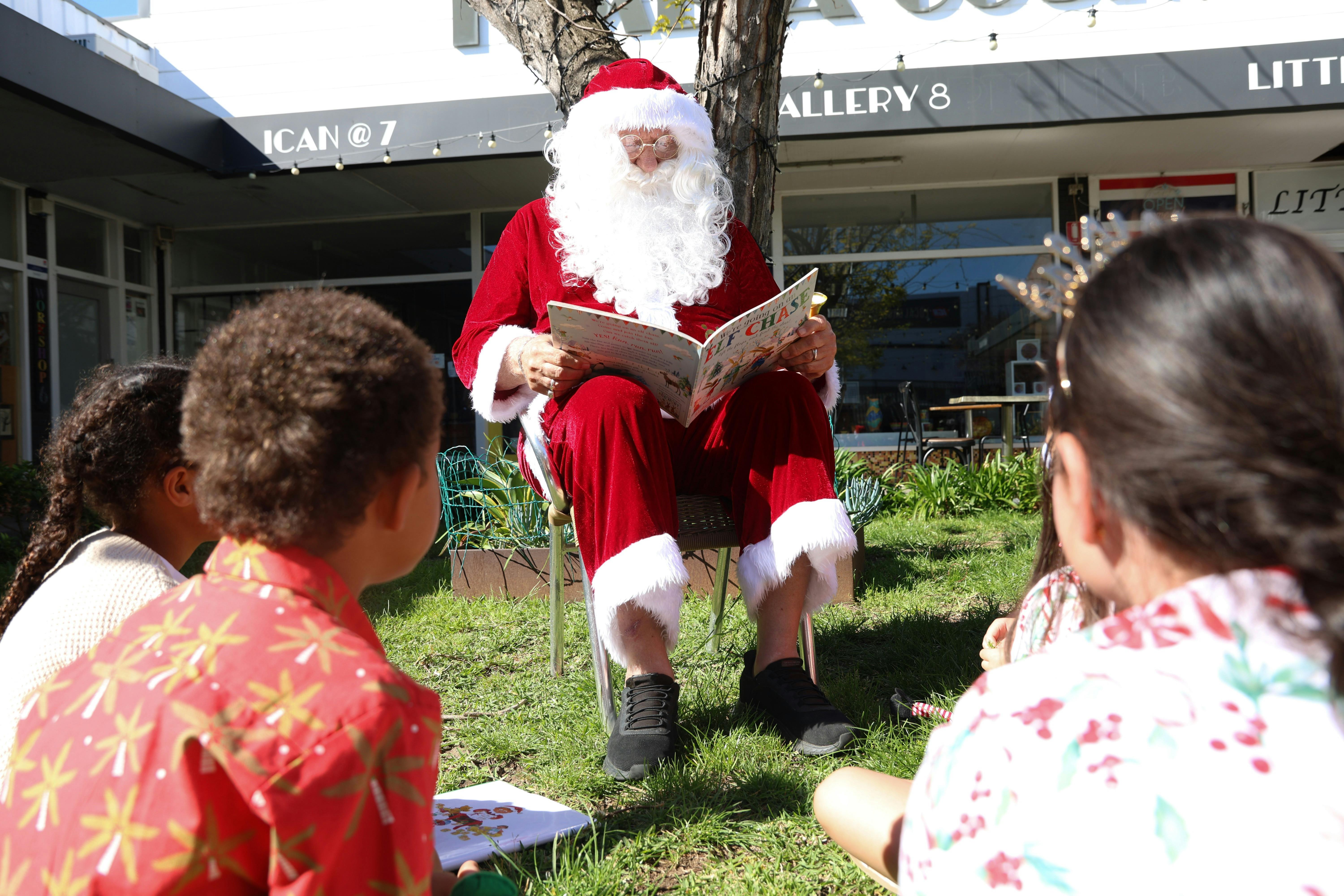 Sanda sat on a chair reading children a book whilst at the wentworth port kembla
