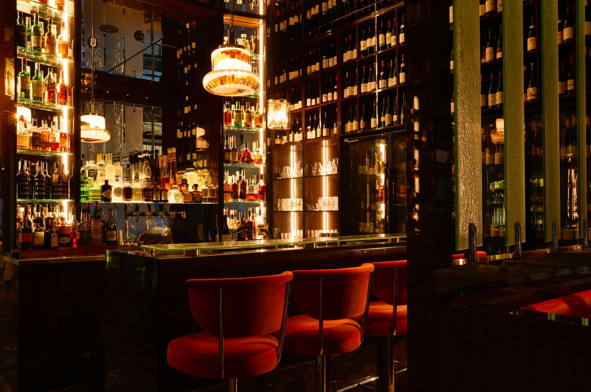 A luxurious bar with red velvet seating