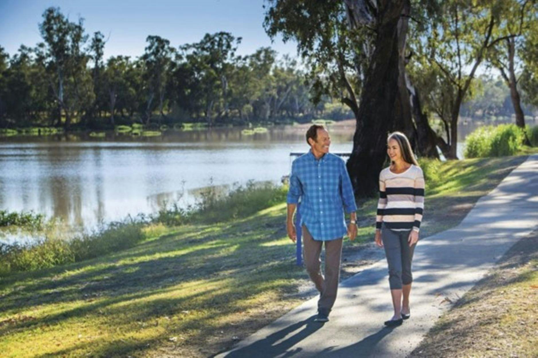 Man and Lady walking on path alongside the Balonne River