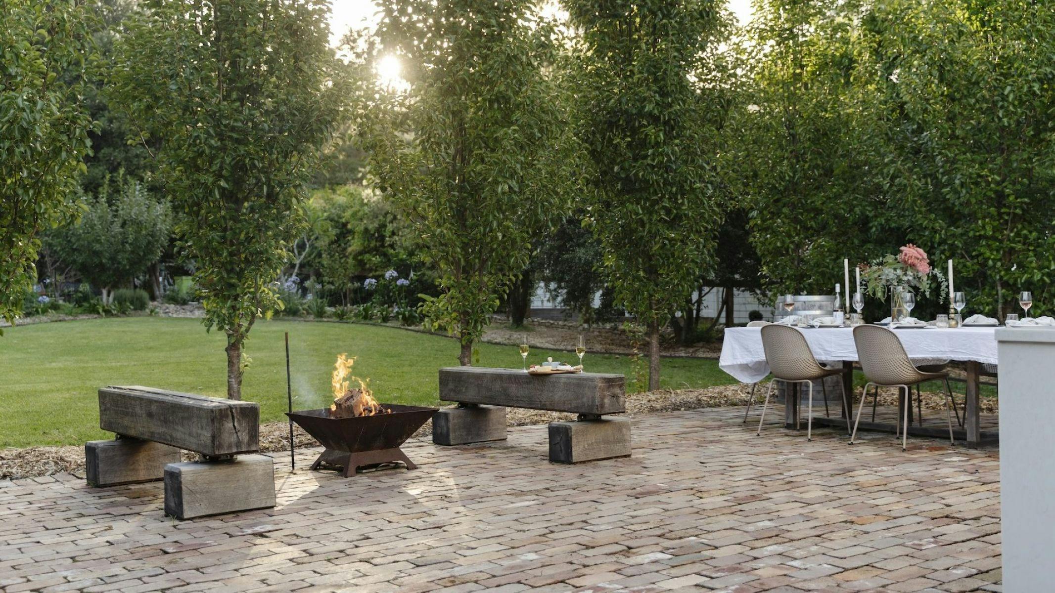 Image of firepit lit and sun going down for an afternoon relaxing in the garden with a glass of wine