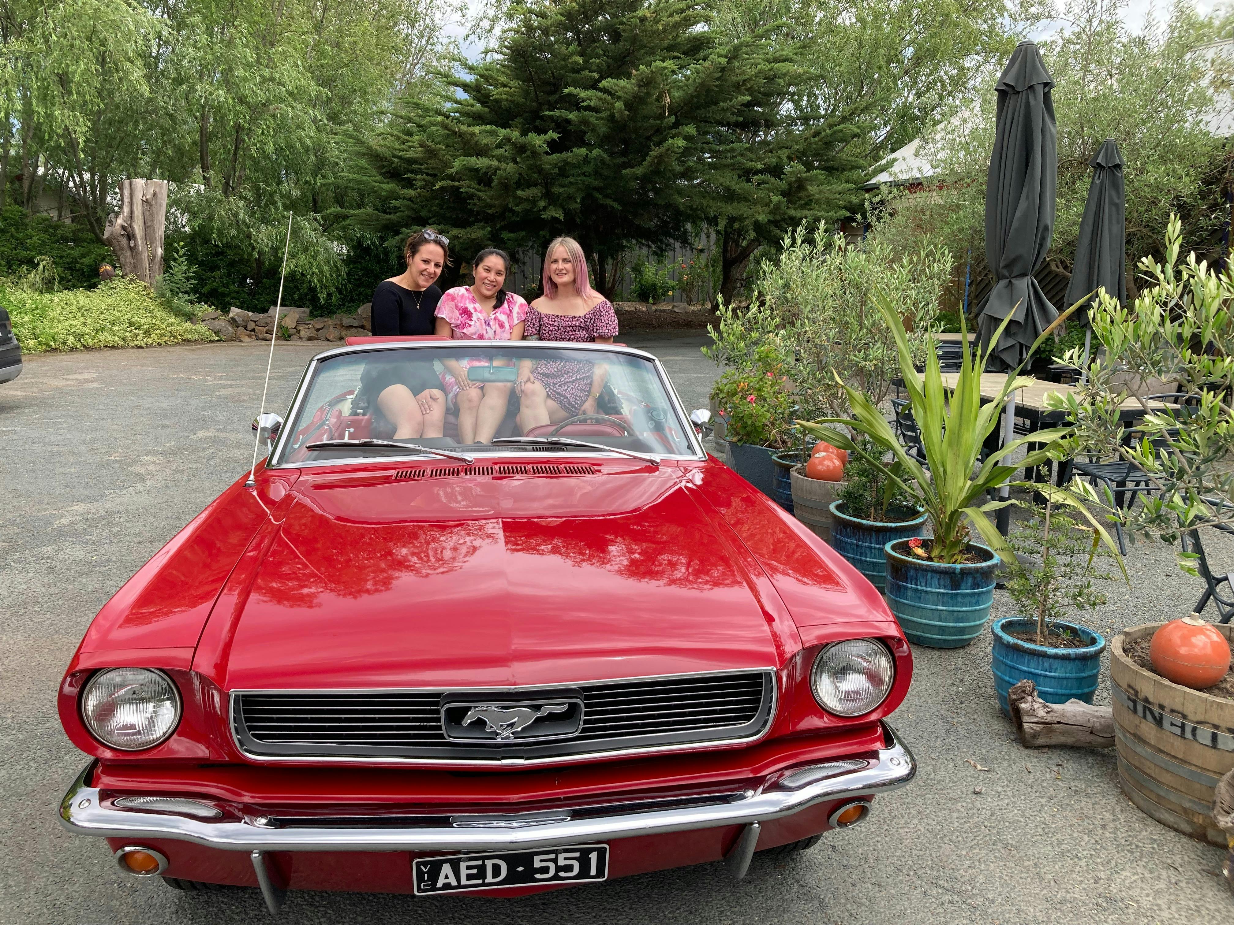 Group of young women in the back of the Vintage Mustang Convertible on a winery tour of Bellarine