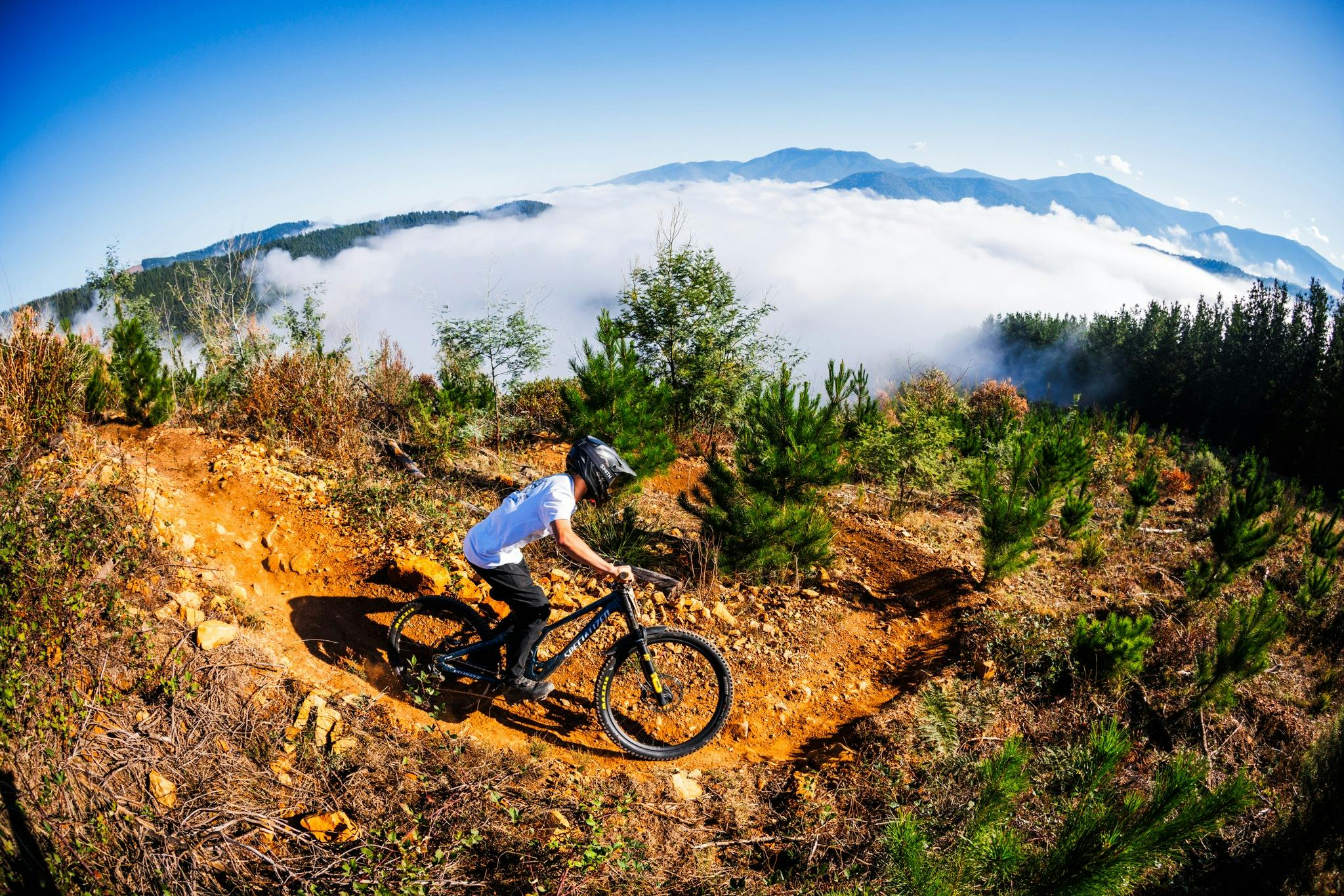 Mountain bike rider on bicycle going down a technical trail at Mystic Bike Park