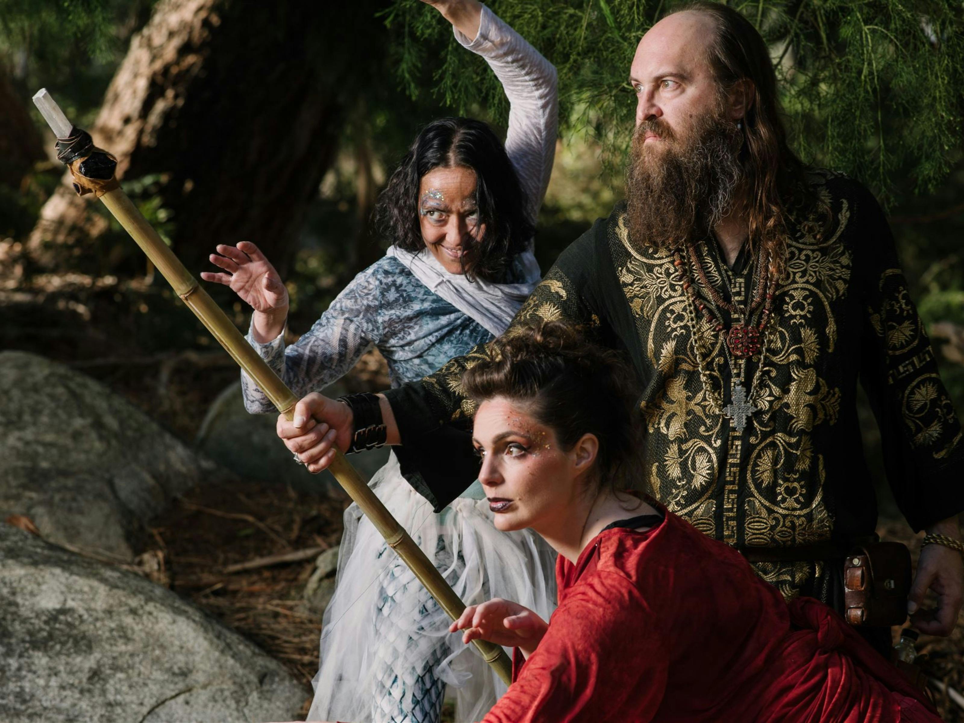 Three characters in intricate clothing, one holding a staff