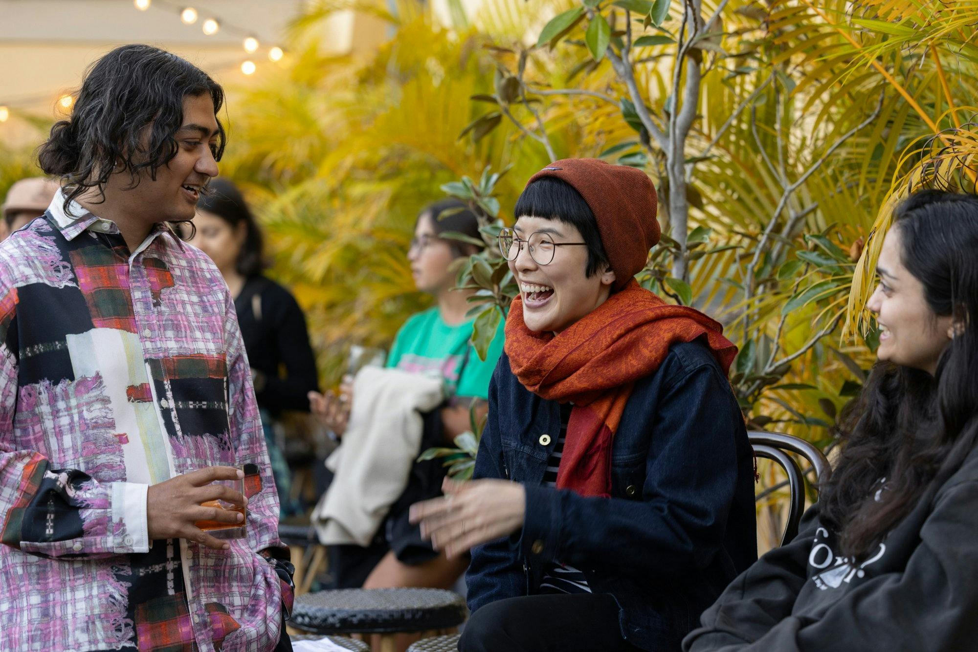 A woman laughing with two friends in an outdoor area