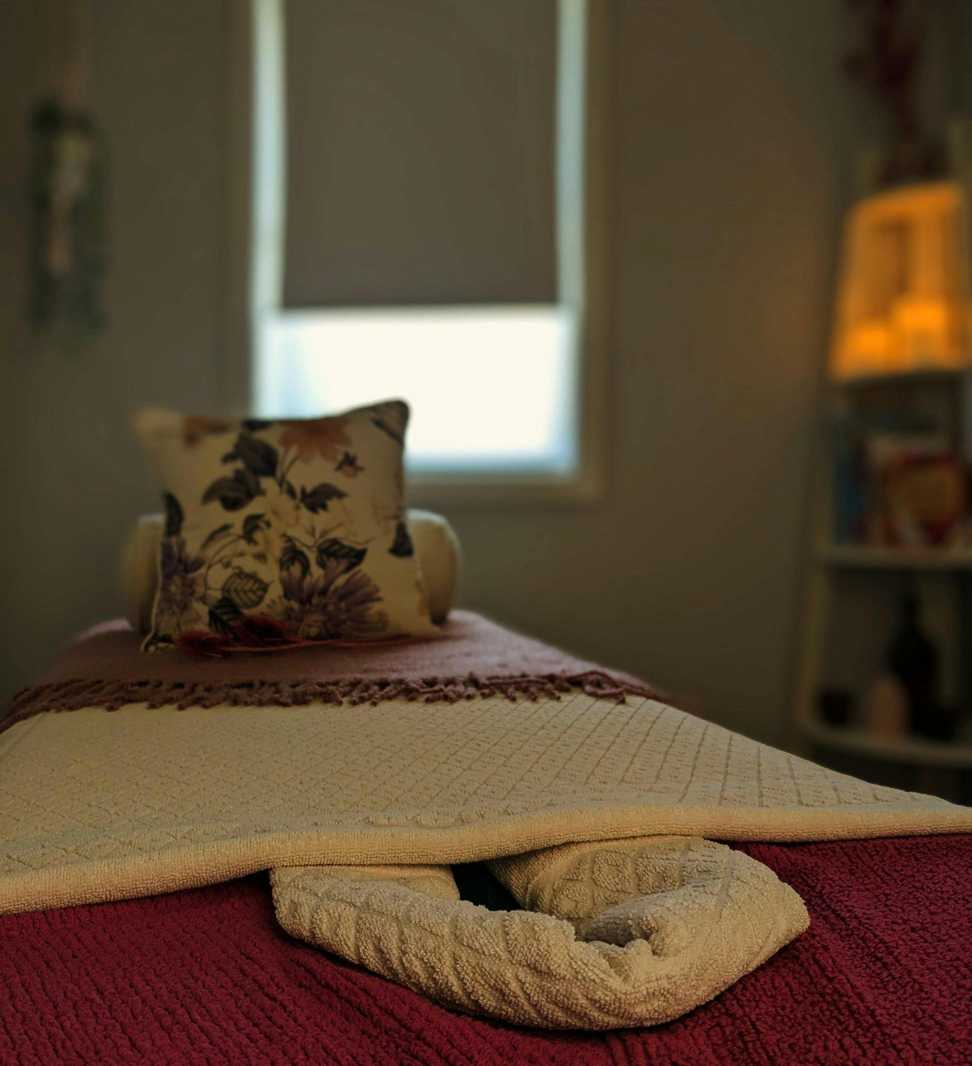 The massage table, prepared with soft towels and blankets, ready for the next client.
