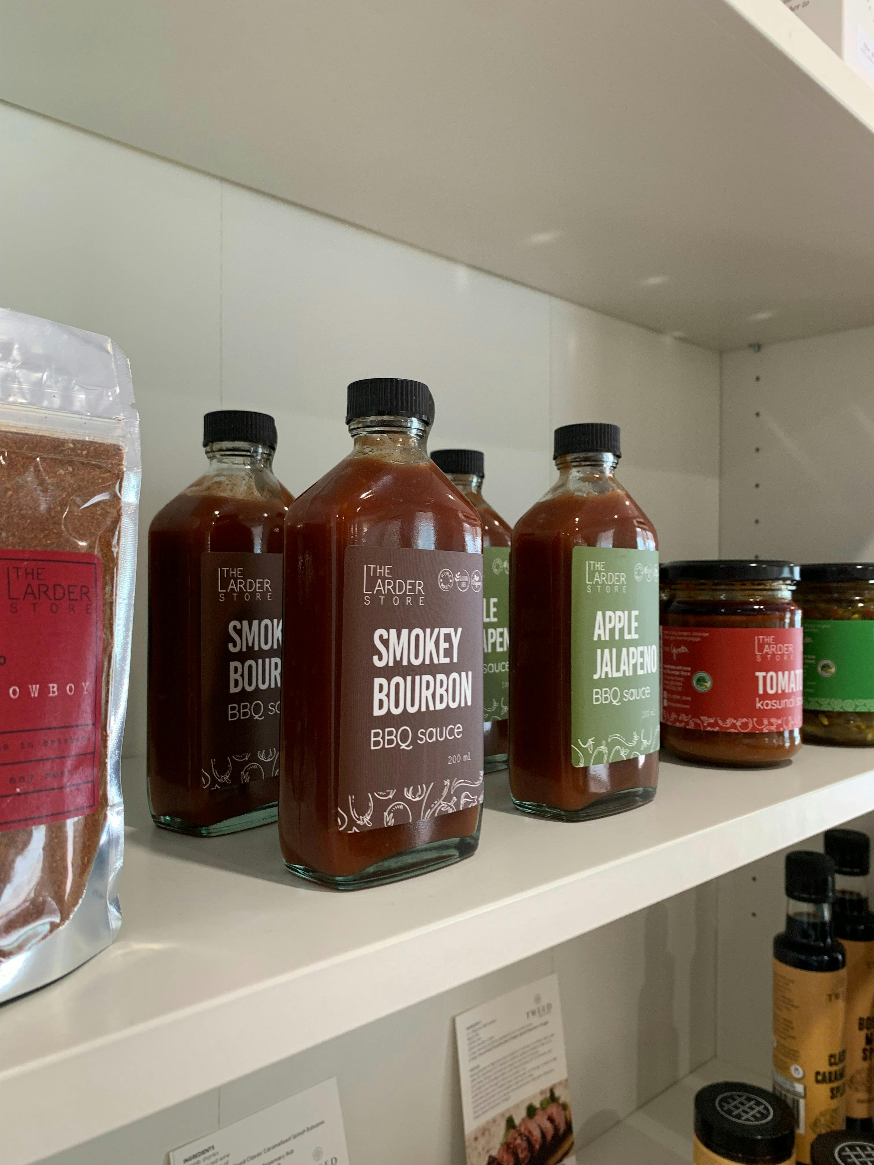 Retail shelf stocking Australian-made products. Bbq sauce from The Larder Store pictured.