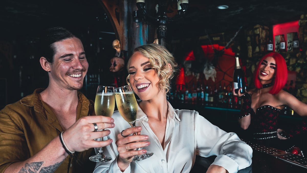 Male and female customers enjoy a glass of champagne at the Dracula's bar.