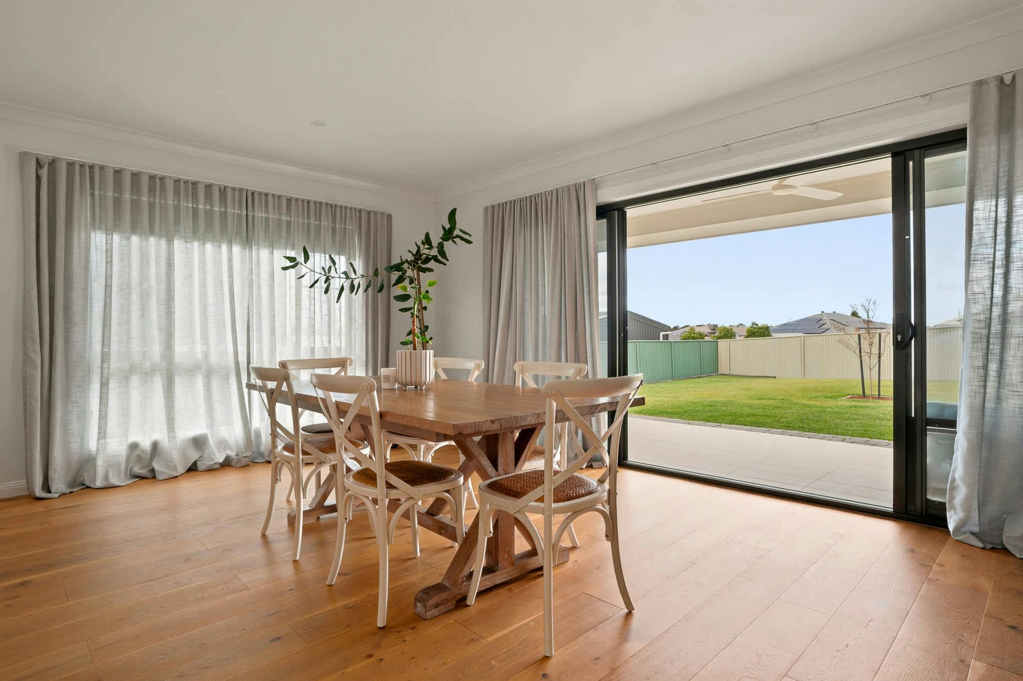 Dining table with wooden table, 8 dining chairs, large sliding doors and large windows