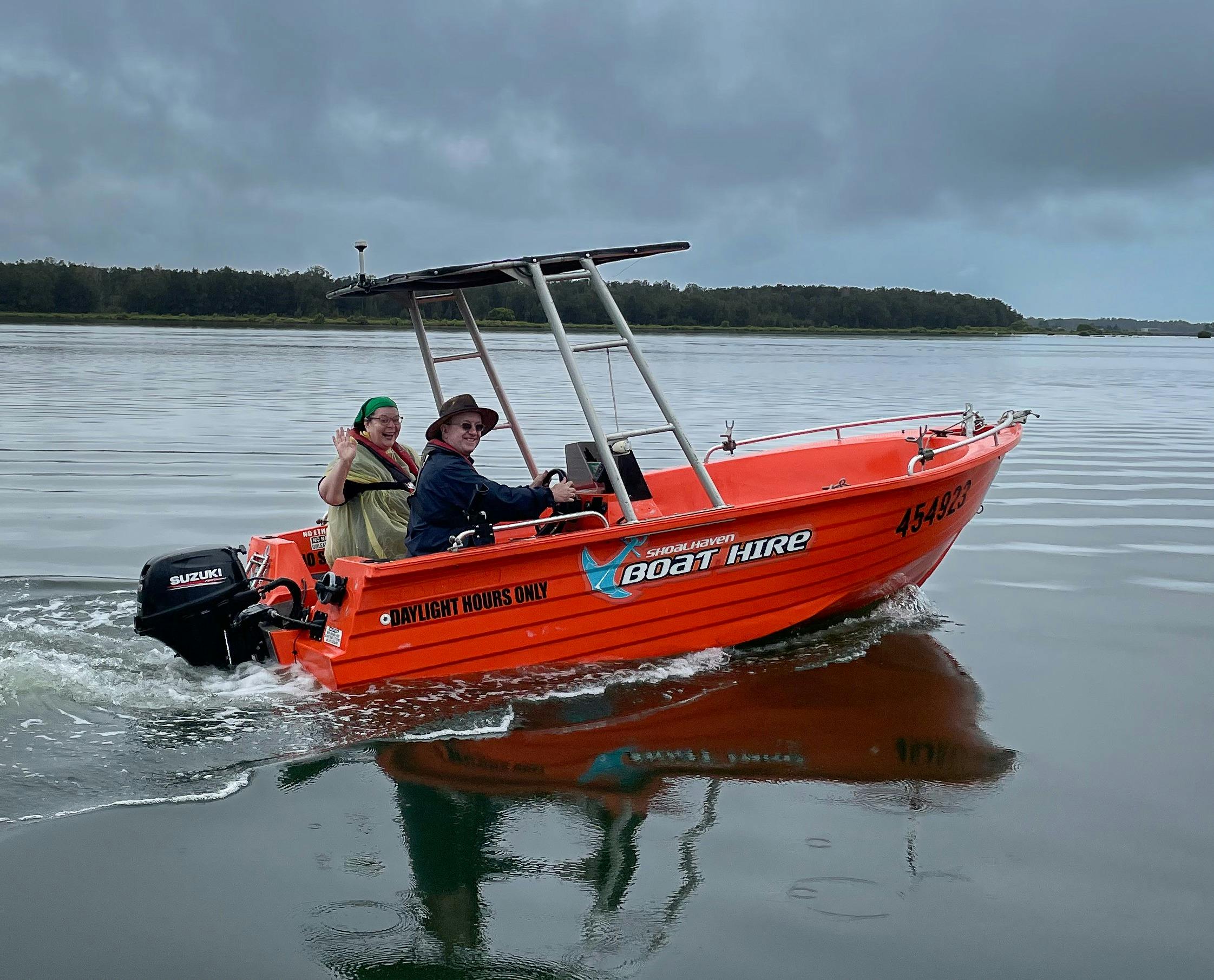 Orange polycraft boat motoring on river