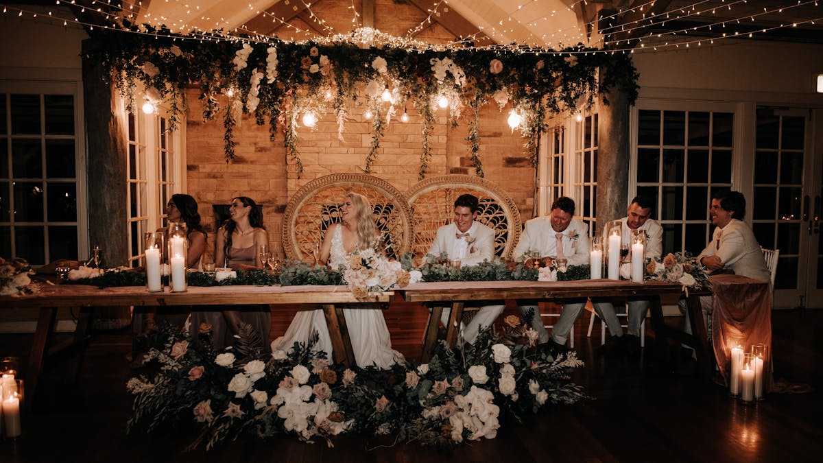 A romantic bridal table endorned with fresh florals arrangements, candlelight and hanging greenery