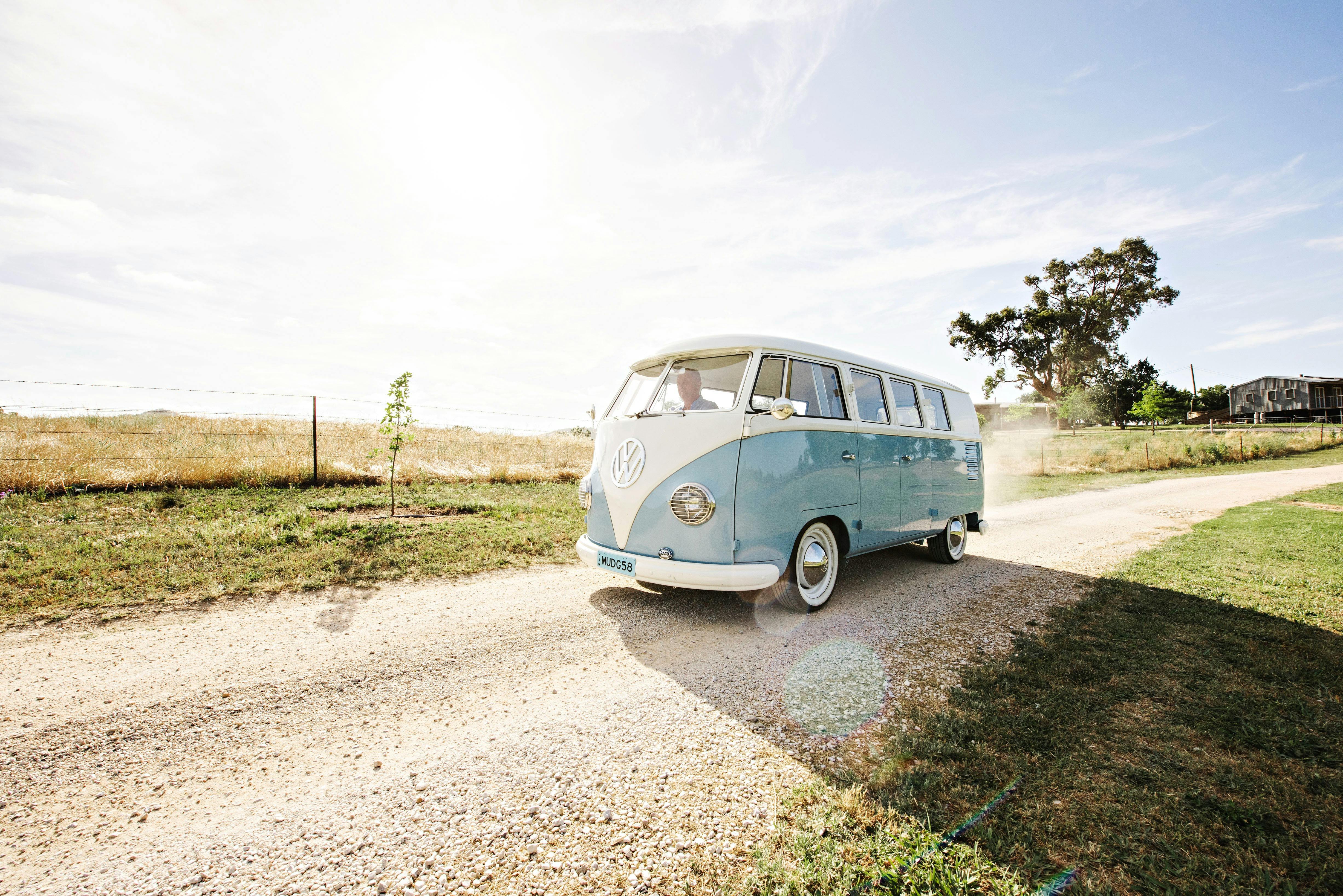 Blue/white VW Kombi Bus on country road