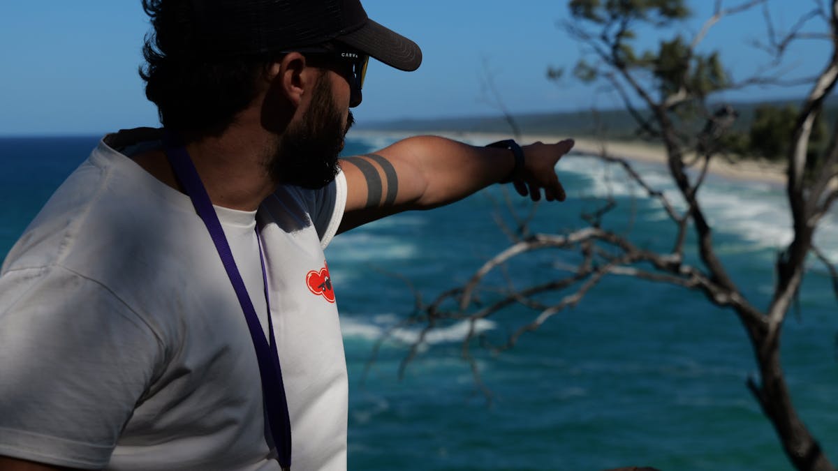 Tour guide pointing toward the coastline during an interpretive walk at Point Lookout on North Strad