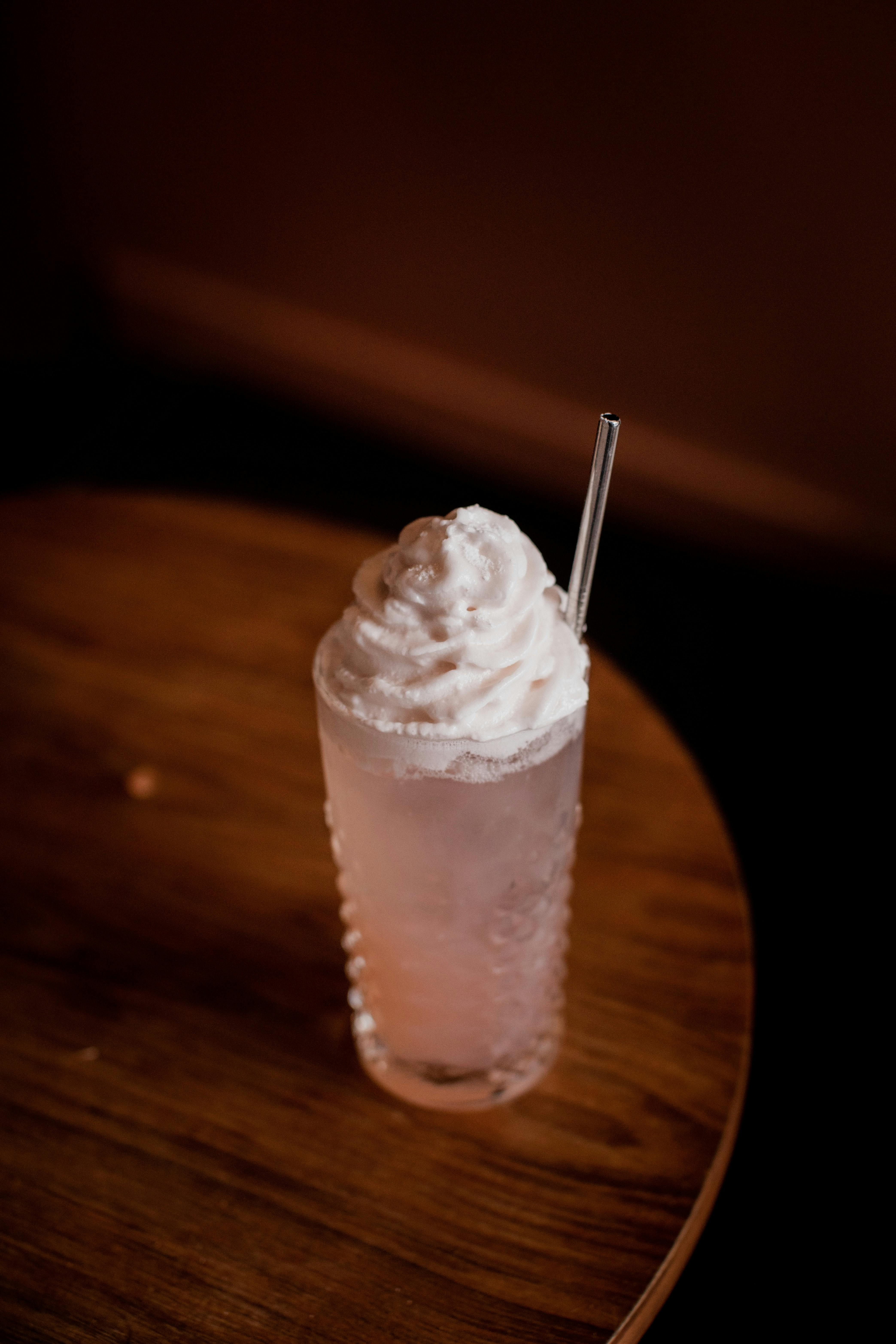 Gin and raspberry cocktail, served in a highball glass, pink in colour with a meringue foam