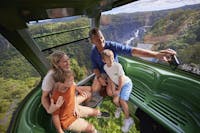 Family in Diamond View gondola over the rainforest taking a selfie with Barron Falls behind