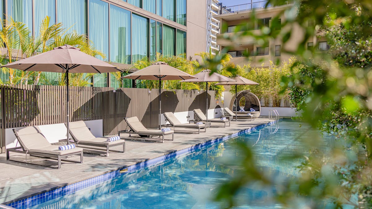 Pool with sun lounges and sun umbrelas