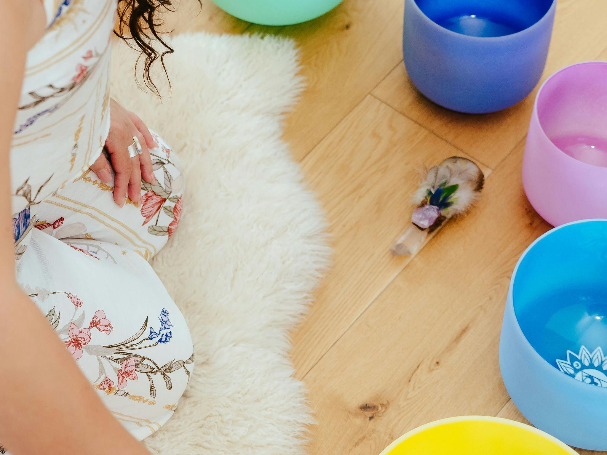 Founder of Harmonic Sanctum Sandy kneeling on a white fur rug with her crystal singing bowls Founder of Harmonic Sanctum Sandy kneeling on a white fur rug with her crystal singing bowls