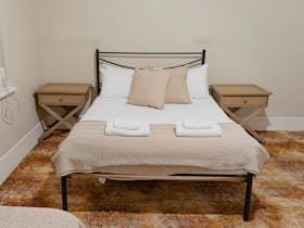 A classic guest room with a neatly made bed, soft lighting, and warm-toned furnishings.