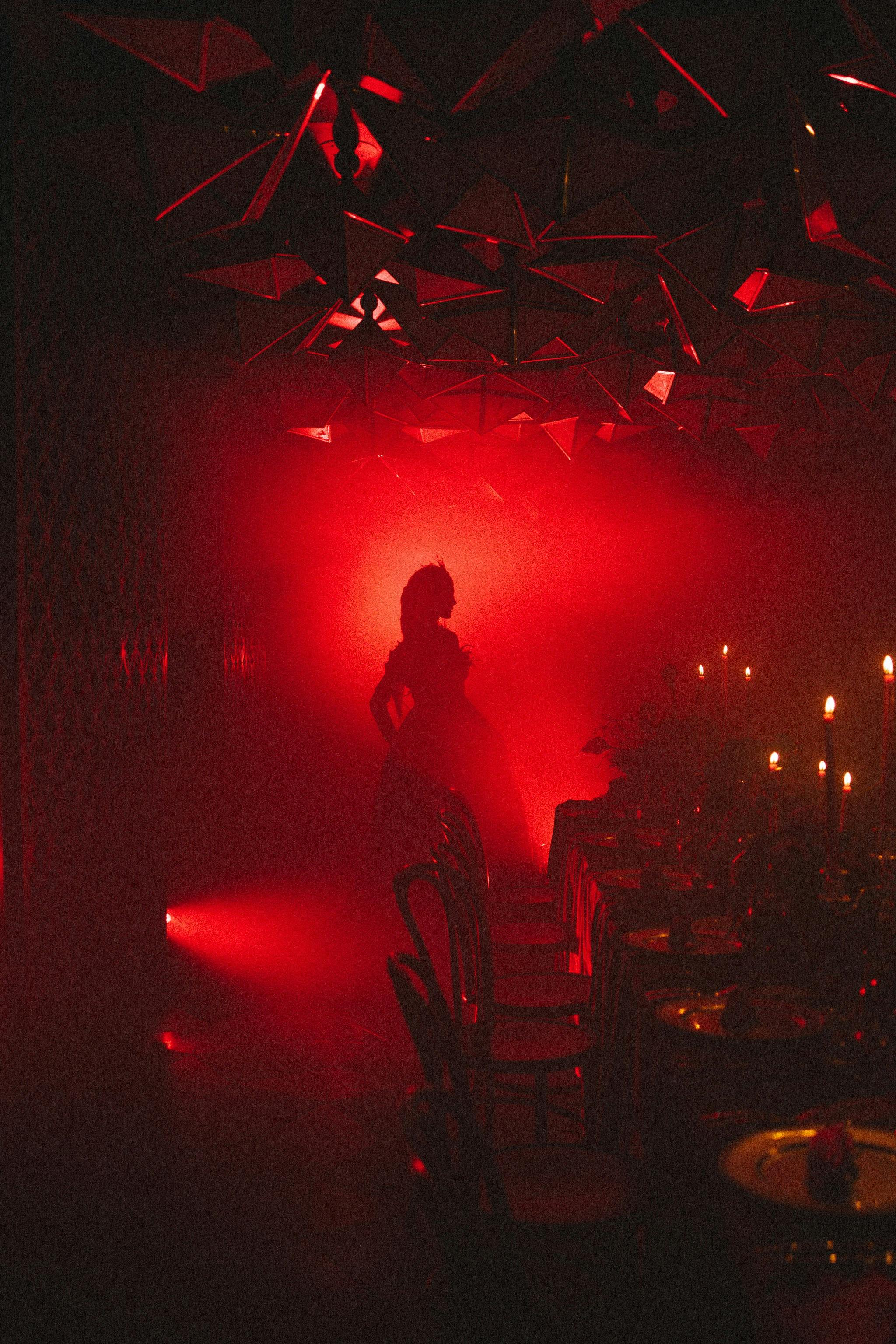 A character silouhetted in red smoke and light