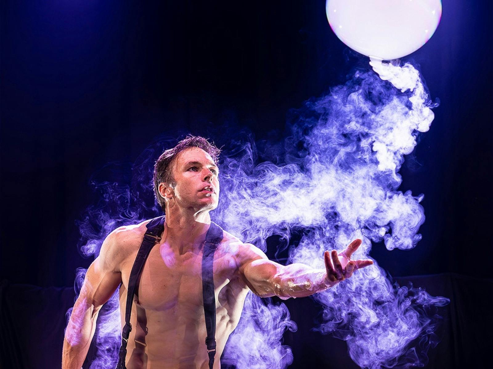 A man standing in mist with a giant bubble