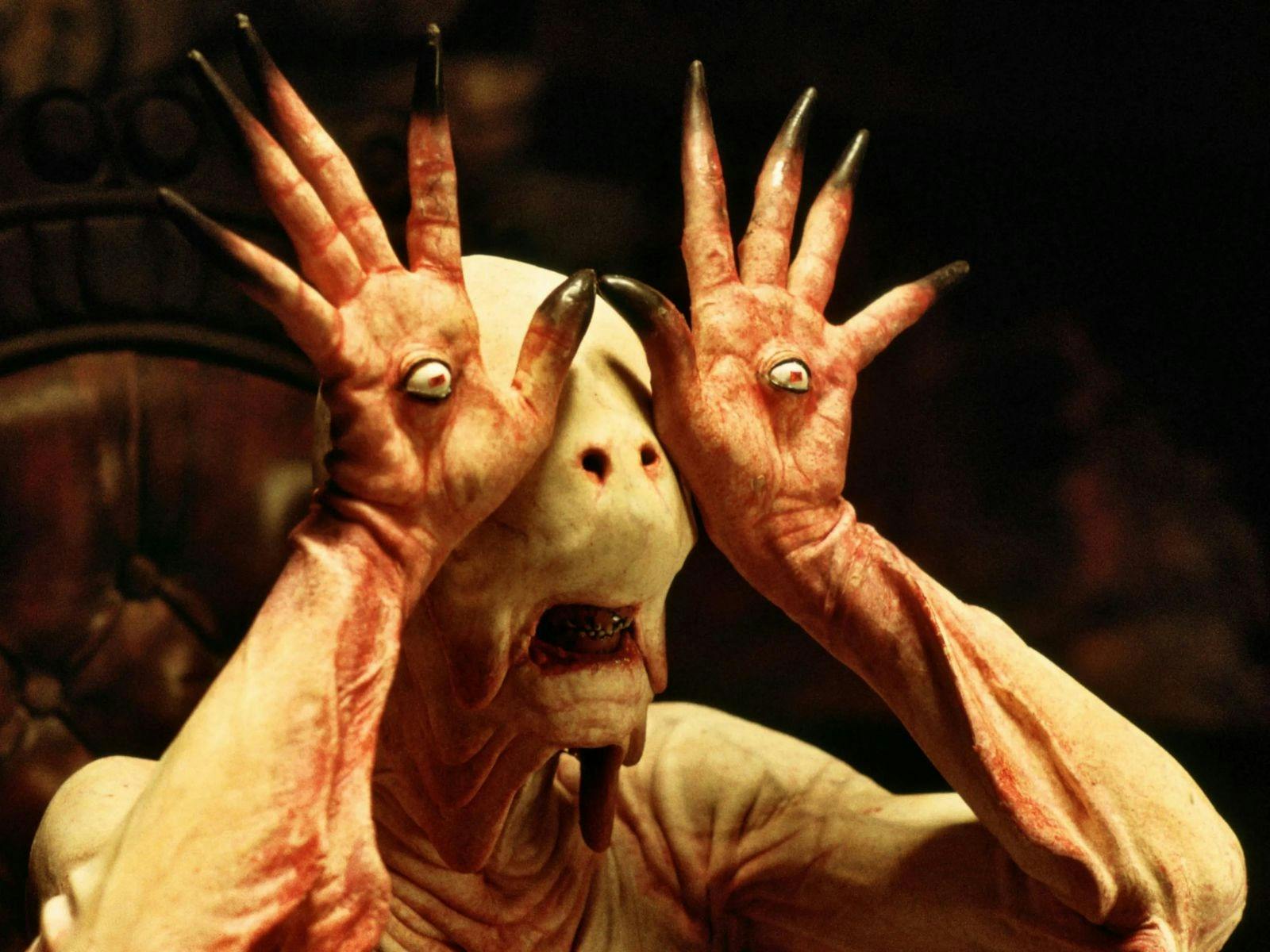 A pale human-like creature holding their hands up to their head. An eyeball is in each palm.