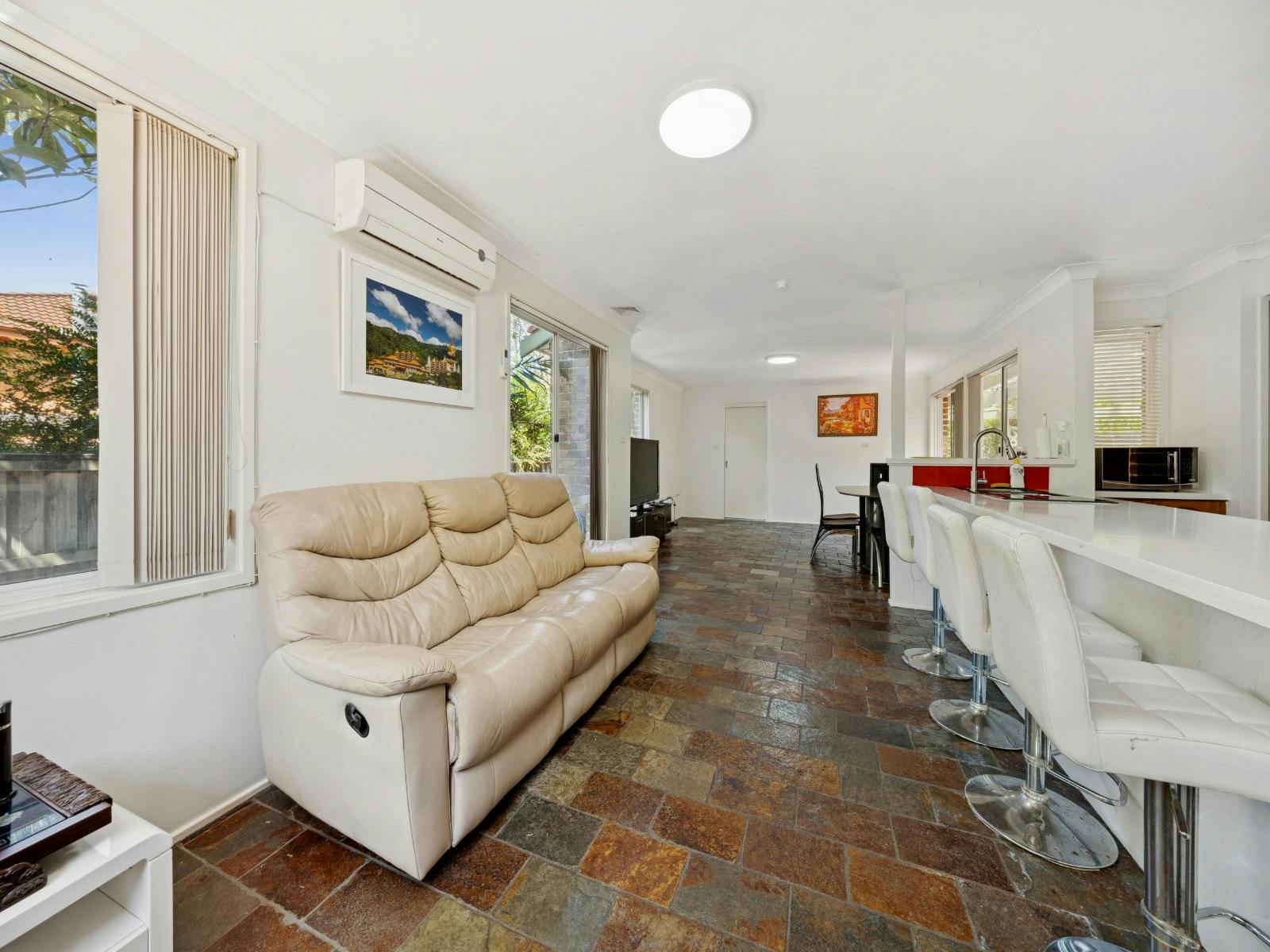 Open-plan living space with cream sofa and adjoining kitchen area