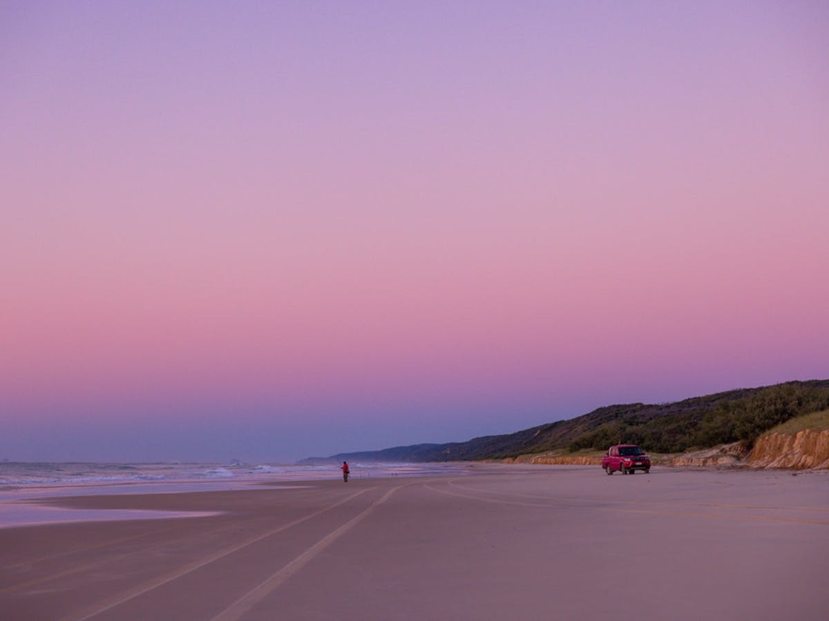 A person fishing while the sunsets on the beach at Double Island Point