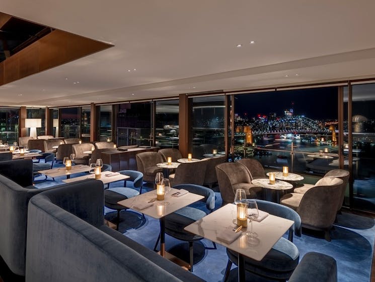 Nighttime bar interior with views of Sydney Harbour Bridge