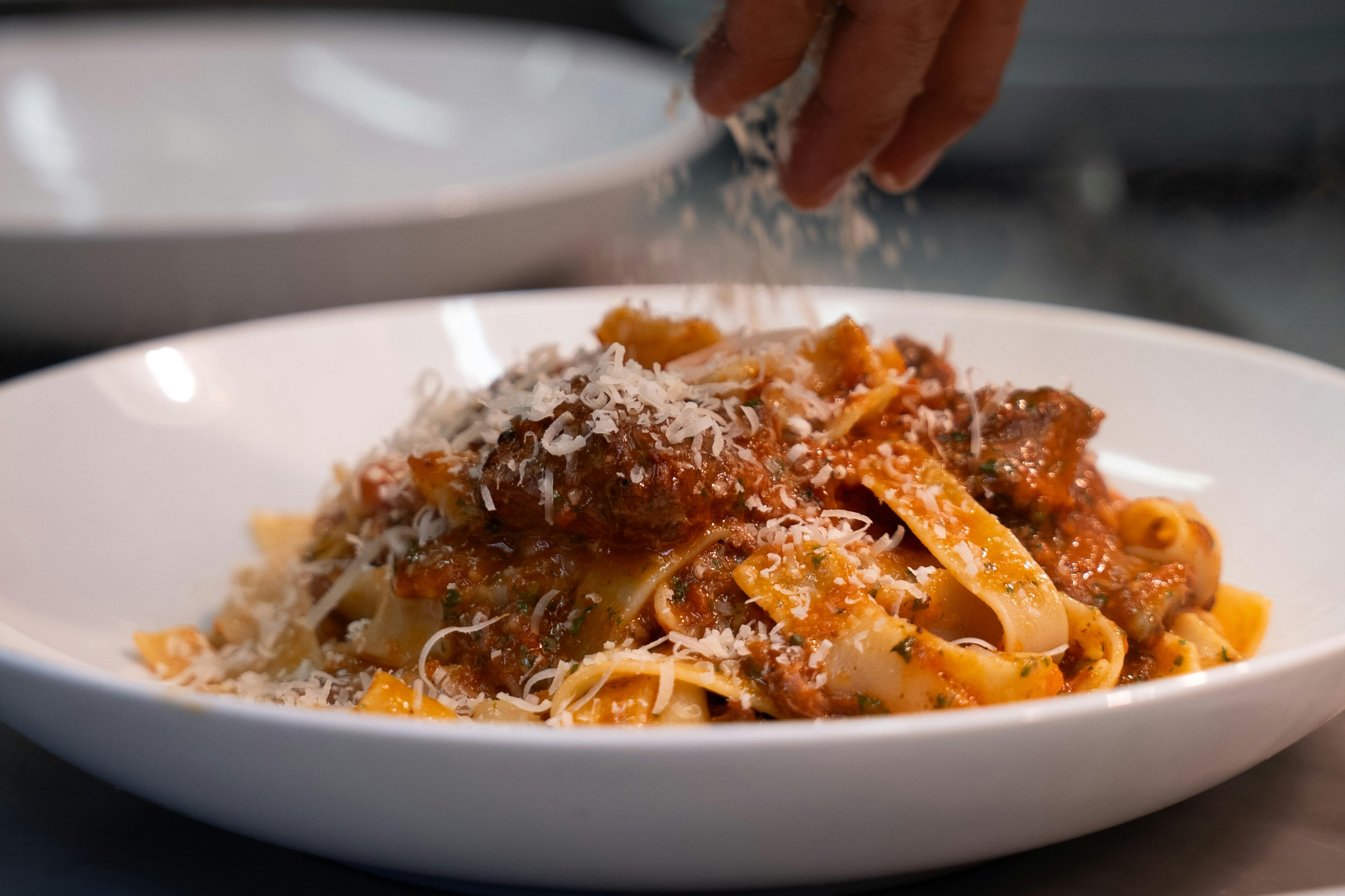 Slow-cooked ragu pasta finished with a generous snow of parmesan.