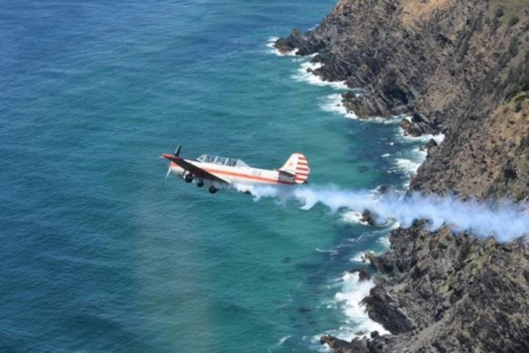 Yak52 flying over coastline