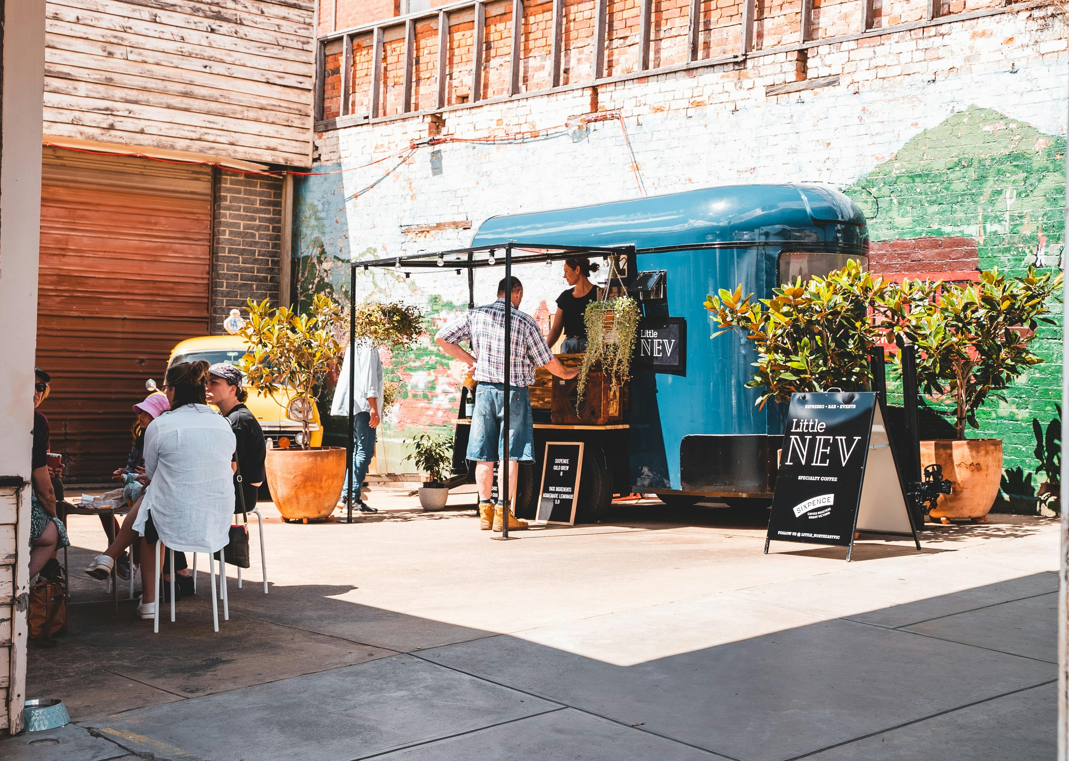 Customers gather sitting down and ordering at the coffee van.