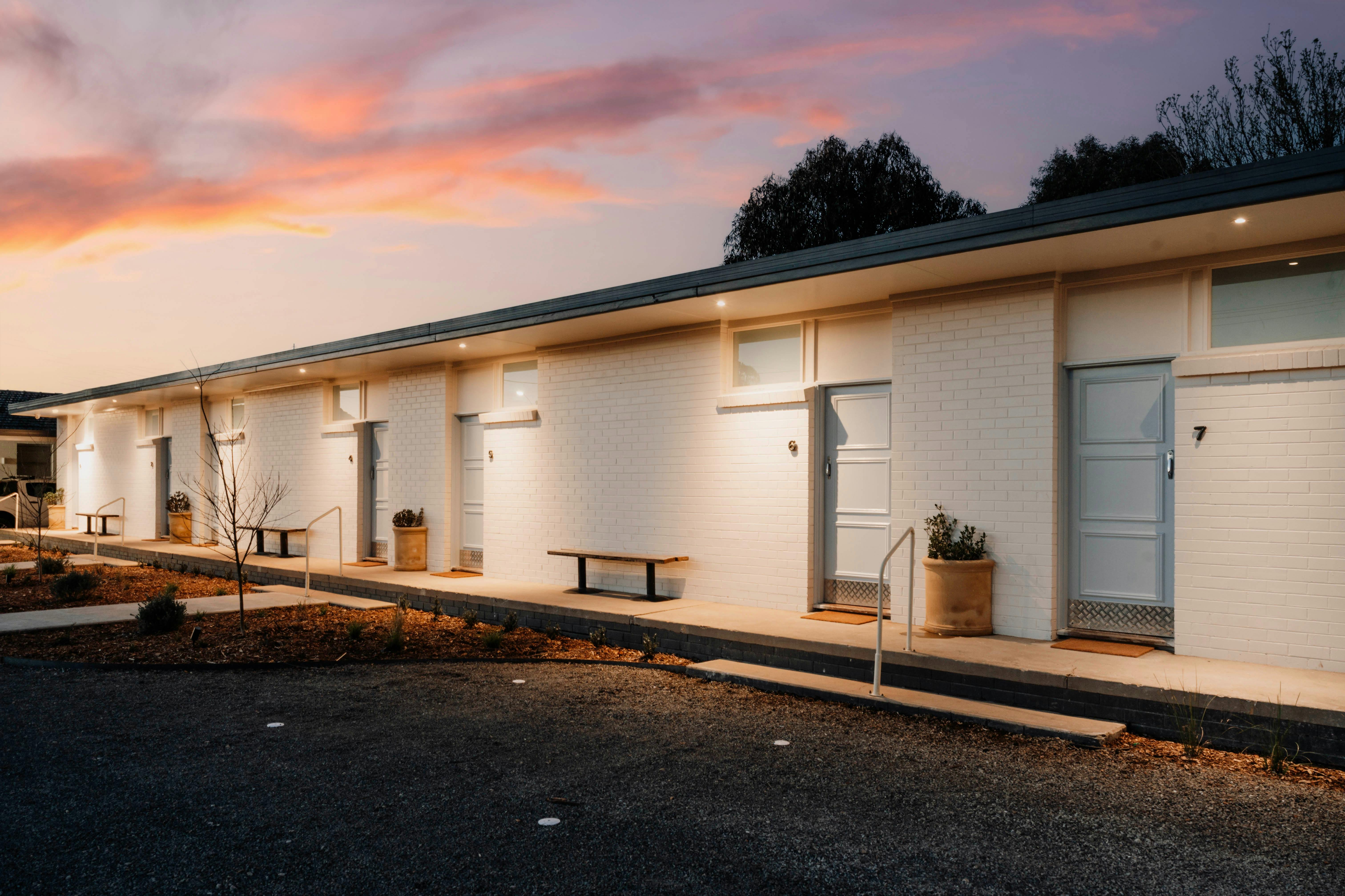 White painted brick motel building with blue doors