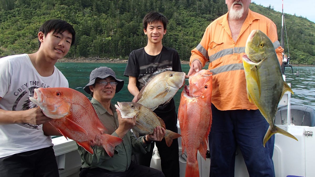 4 anglers holding their catch of the day. Red throat Emperor