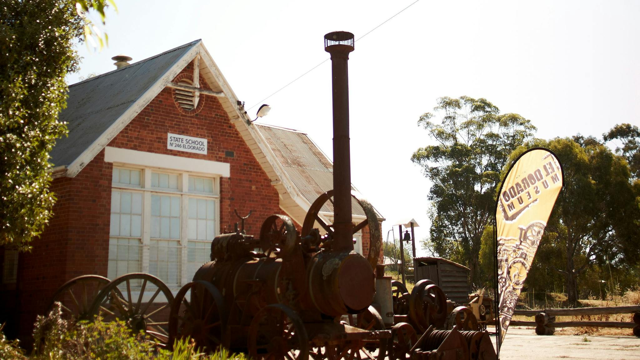 Historic farm equipment outside museum  on a sunny day.