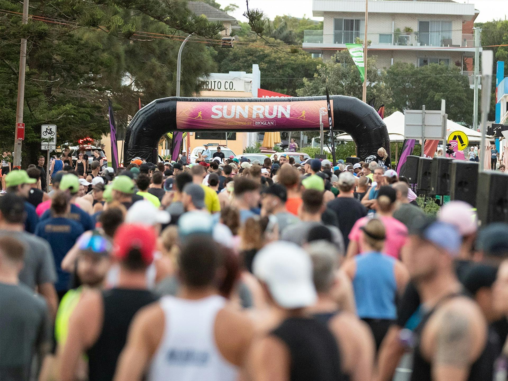 Crowd of runners at start line of Sun Run waiting to start race