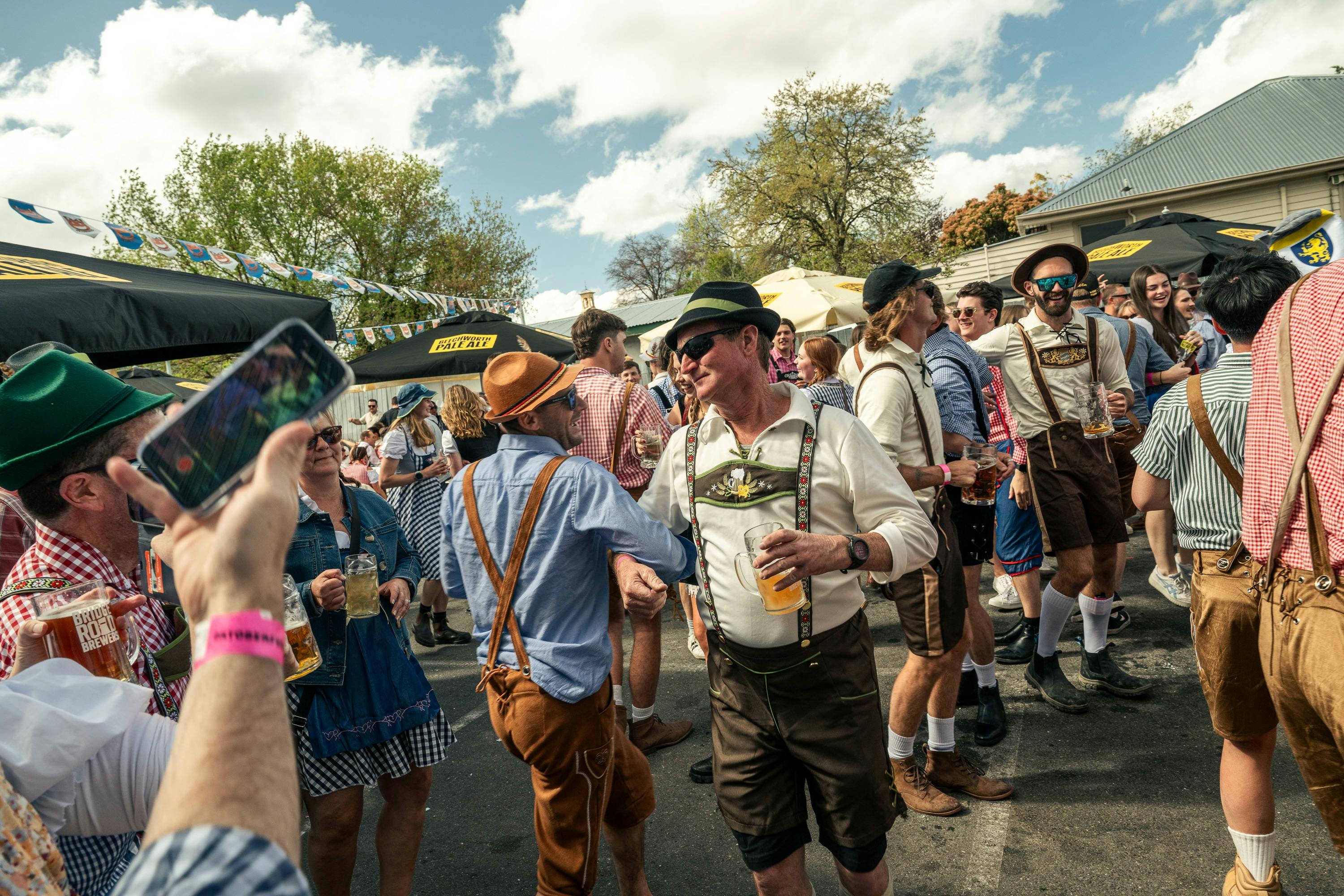 Two men dancing in the crowd laughing with arms linked.