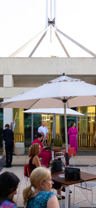 The Queen's Terrace at dusk filled with people.