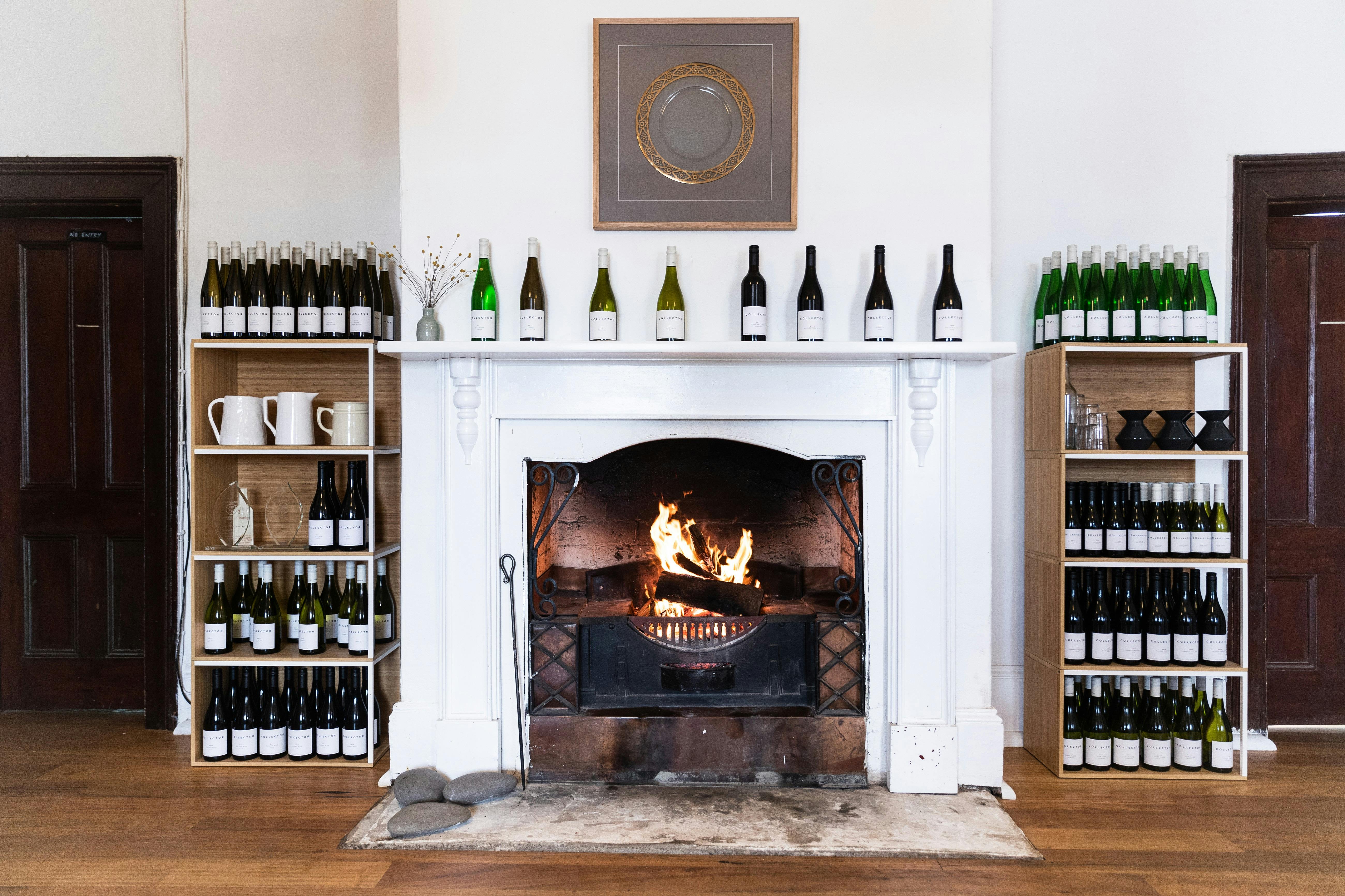 A blazing fire is surrounded by shelves of wines and awards in the historic Old Collector Inn.