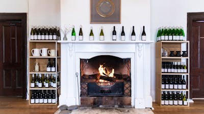 A blazing fire is surrounded by shelves of wines and awards in the historic Old Collector Inn.
