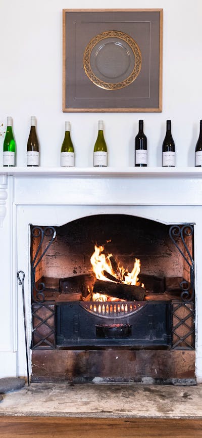 A blazing fire is surrounded by shelves of wines and awards in the historic Old Collector Inn.