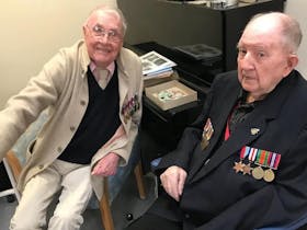 Two returned soldiers at the Anzac Day service in Penola. Both have their service medals on coats.