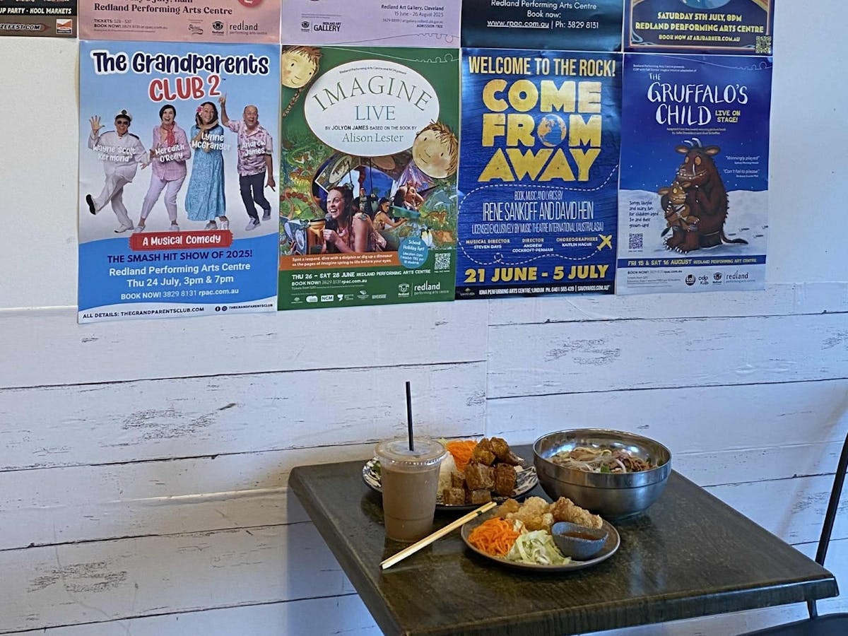 A table full of food next to a white wall with posters A table full of food next to a white wall with posters