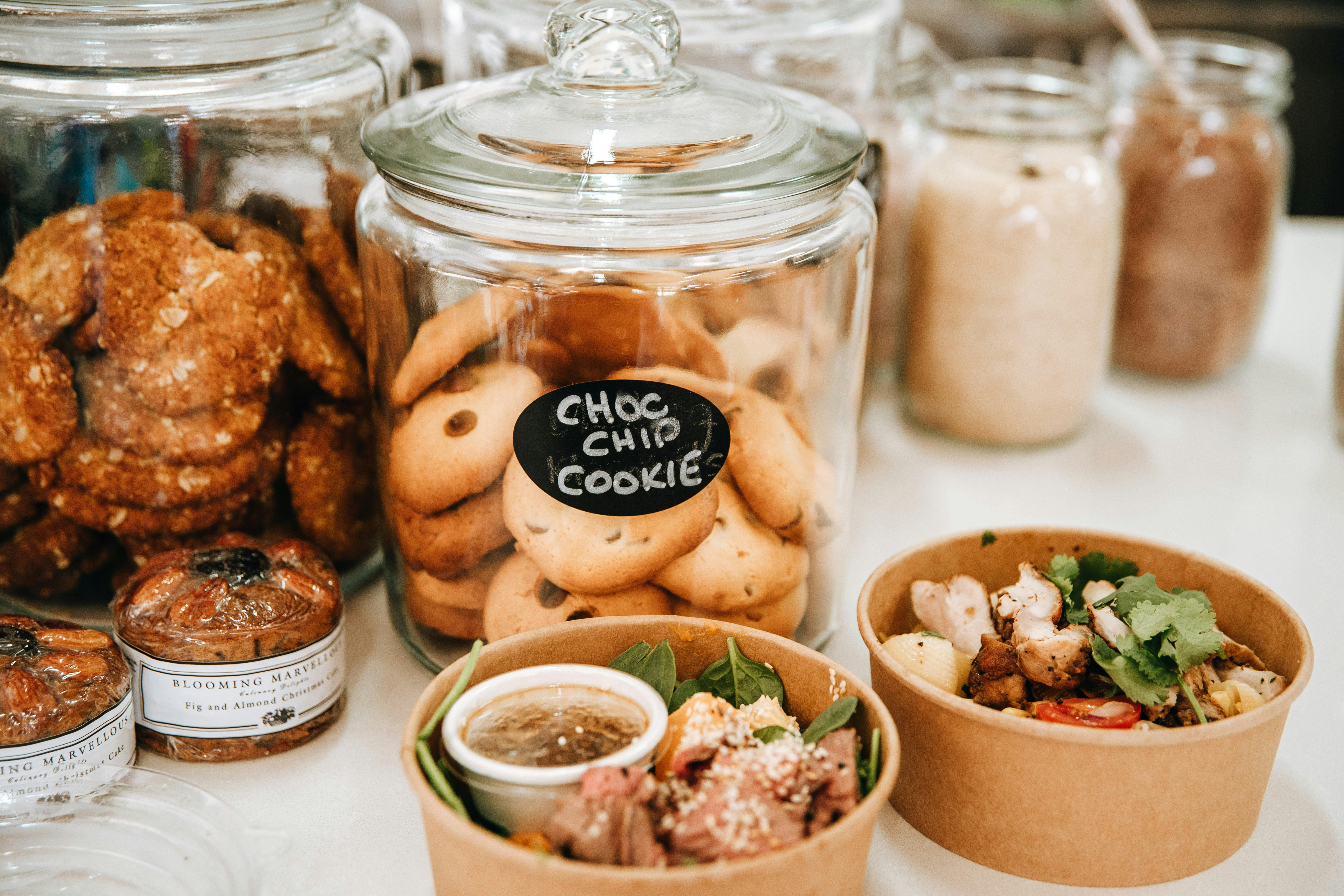 biscuits in glass jars with two takeaway salads near them