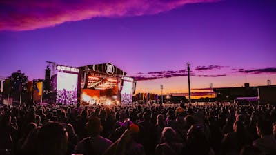 A crowd of people enjoying music at dusk at Spilt Milk Festival