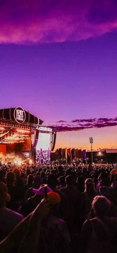 A crowd of people enjoying music at dusk at Spilt Milk Festival